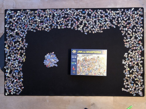 Jan van Haasteren ‘Stichting kringloopcentrum Spullenhulp’ stukjes uitgelegd op mat en doos erbij